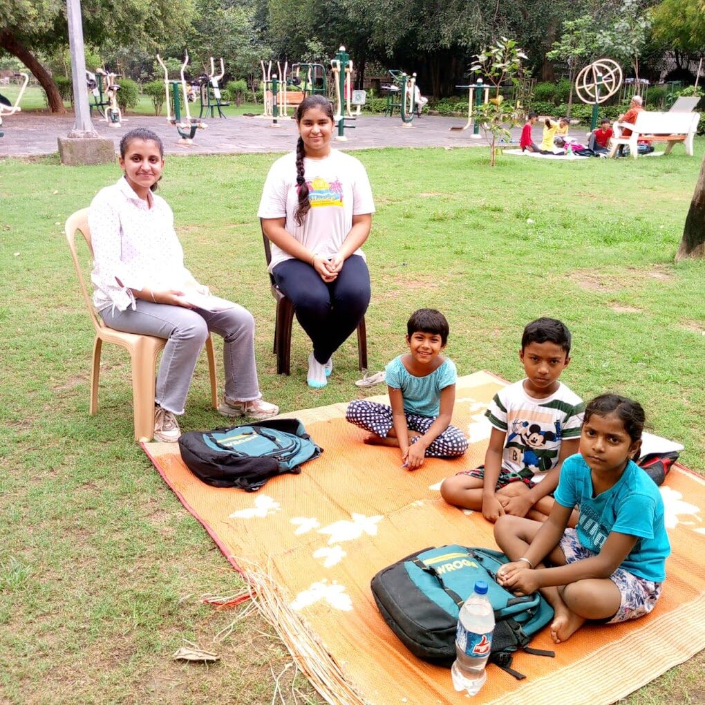 SVSPF volunteers conducting an outdoor learning session with underprivileged children and their school bags